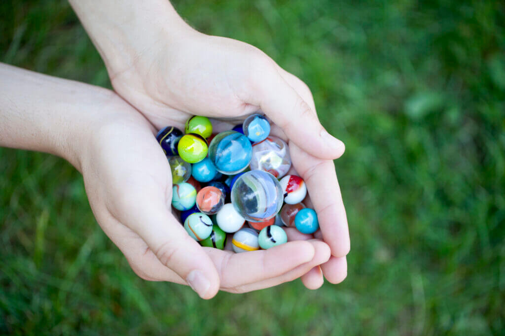 a hand with colorful marbles